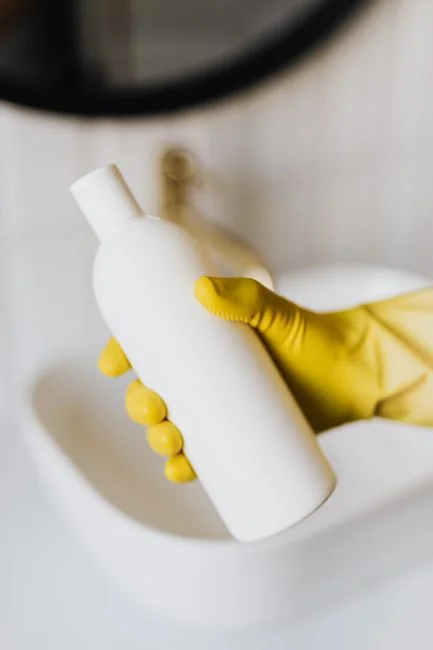 A clean and organized home office desk with a cleaner bottle and sponge, emphasizing simplicity and functionality.